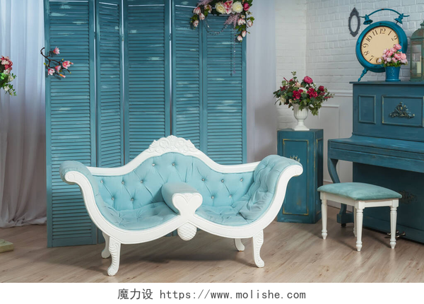 客厅里的折叠式屏风前放着浅蓝色经典沙发浅蓝色经典沙发的背景是客厅里的折叠式屏风.带有蓝色钢琴的经典风格的白色客厅。春季夏季室内装饰